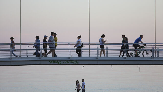 Personas paseando por un puente del pase marítimo de Málaga